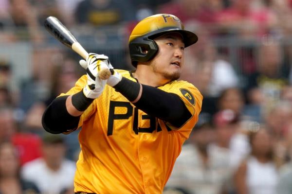 Ji Man Choi hitting an RBI double in Pirates vs Phillies ba<em></em>seball game in Pittsburgh, wearing yellow uniform with a ba<em></em>seball bat in hand.