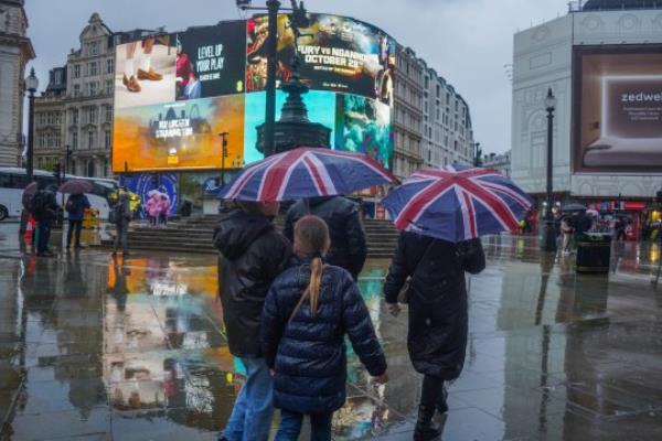 Mandatory Credit: Photo by Amer Ghazzal/Shutterstock (14172345k) Pedestrians in Piccadilly Circus sheltering with umbrellas during heavy rain showers. The Met Office has issued flood a<em></em>lert as heavy showers, 70mph winds are set to hit Southern England and Scotland this weekend Seaso<em></em>nal Weather, London, United Kingdom - 29 Oct 2023