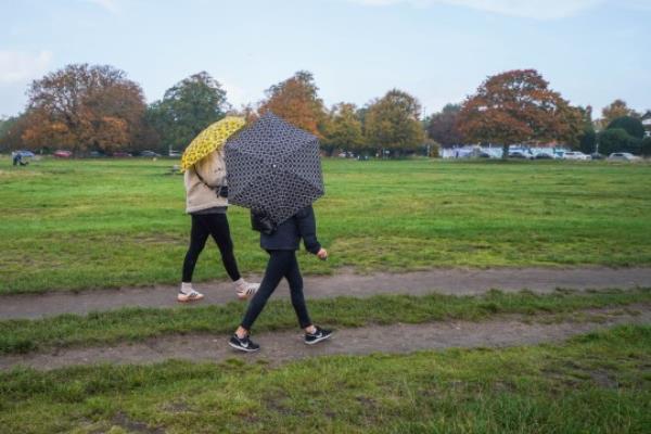 Mandatory Credit: Photo by Amer Ghazzal/Shutterstock (14171110h) Walkers with umbrellas on Wimbledon Common, south west Lo<em></em>ndon during rain showers. The Met Office has issued flood a<em></em>lert as heavy showers, 70mph winds are set to hit Southern England and Scotland this weekend Seaso<em></em>nal Weather, Wimbledon Common, London, United Kingdom - 28 Oct 2023